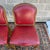 A set of three mid 20th century French Louis XV fauteuil dining chairs in tacked red vinyl with fruitwood frames. Circa...