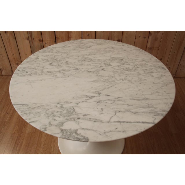 Knoll Tulip table by Eero Saarinen. Round 107 cm Calacatta marble top. Cast iron base with Rilsan coating. Stamped under...