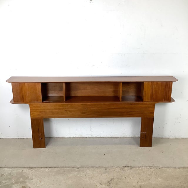 This Mid-Century Modern storage headboard exemplifies the era’s thoughtful integration of form and function, combining...