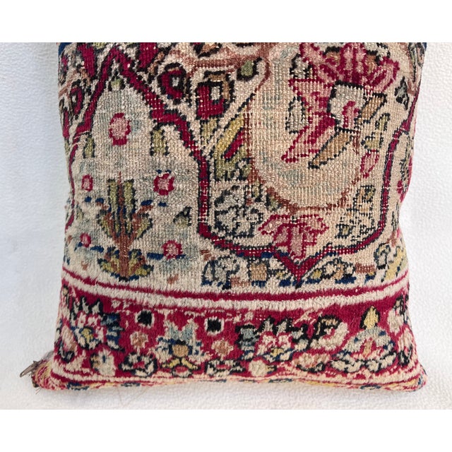 Decorative pillow upholstered in a 19th century Kerman rug fragment, featuring charming floral flowerhead motifs and an...