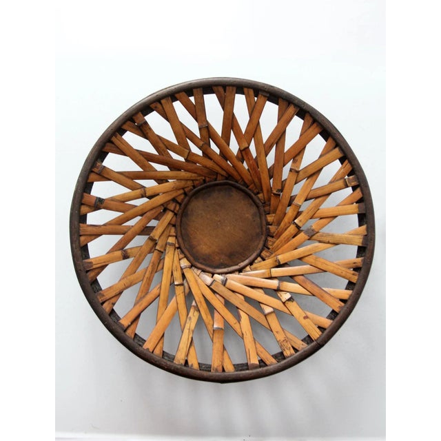 This is a vintage woven rattan basket. Featuring a dark wood frame and base, the decorative bowl has a dynamic woven...