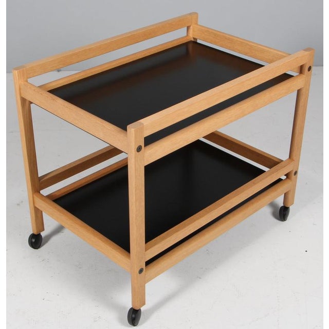 Børge Mogensen tray table with frame of oak. Plates of black laminate. Mounted on wheels. Model 5370, made by Fredericia...