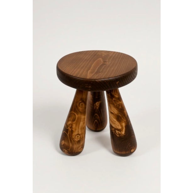 A custom Claude Home Louie stool. Dark wood tripod base with a round seat. New, unused. This model is discontinued. 12"...