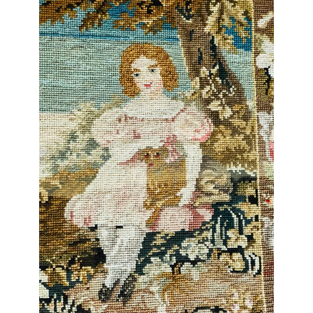 Beautiful birds eye maple frame with gold filet. Textile of a young girl holding her dog. Floral garland surrounding the...