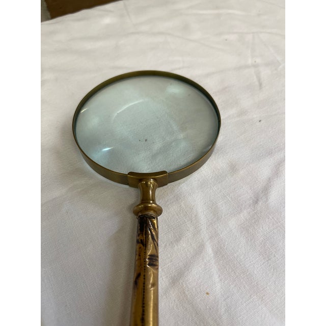 The Victorian magnifying glass features a circular convex glass lens secured within a brass rim. This is a magnificent...