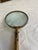 The Victorian magnifying glass features a circular convex glass lens secured within a brass rim. This is a magnificent...