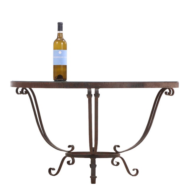 Striking French round occasional table from the Art Deco period, featuring a hand-hammered iron frame and a reflective...