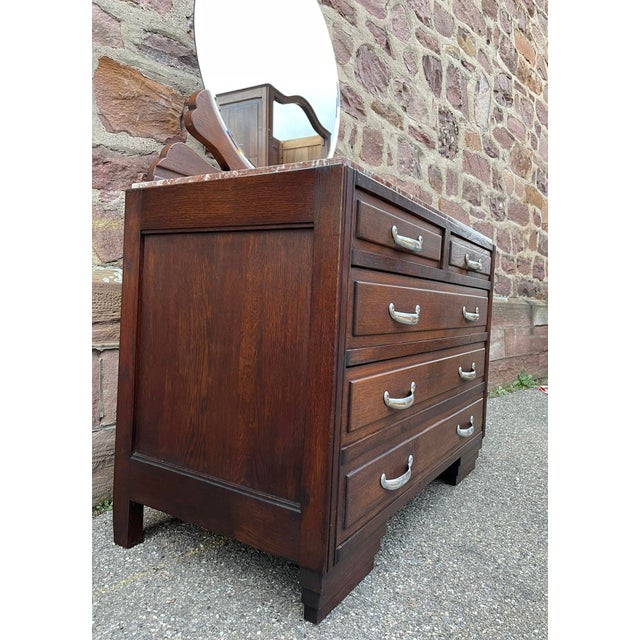 Beautiful Mid-century Art Deco chest of drawers from the 1950s in solid oak topped with marble and topped with a round...