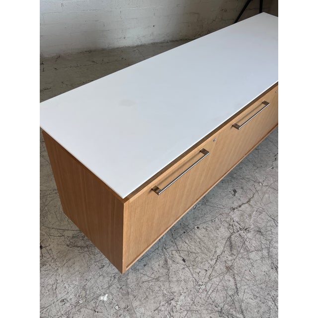 Modern locking blonde credenza, very heavy and well made, featuring a floating stone top, brushed aluminum and adjustable...