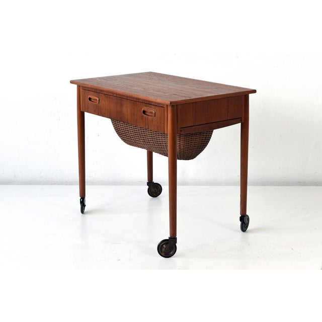 This teak sewing box table on castors was produced in Denmark in the 1960s.