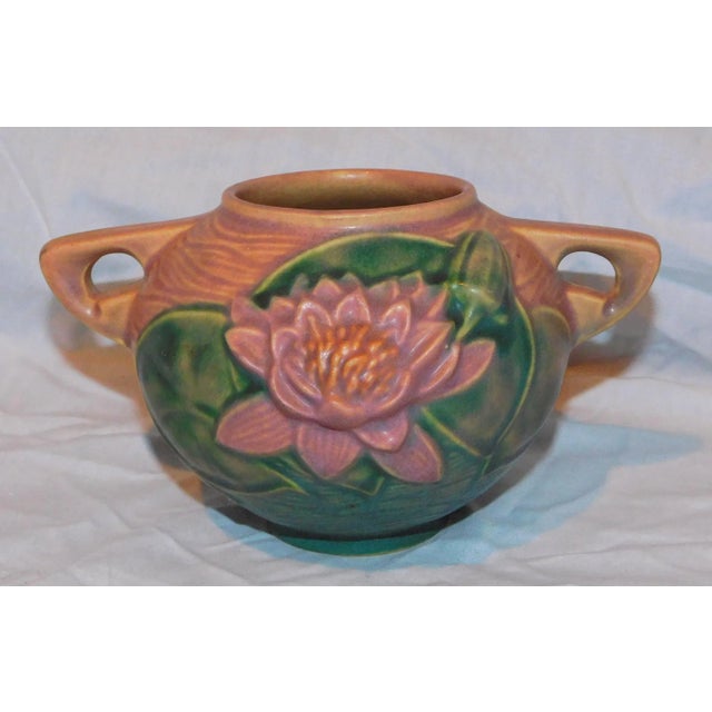 Roseville Water Lily two handled vase with pink flower against a terracotta ground. Design number 4374. A gorgeous...