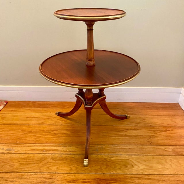 Lovely two tier, three leg, salon/parlor side table. Gold accents on the metal claw feet and around each table edge and...