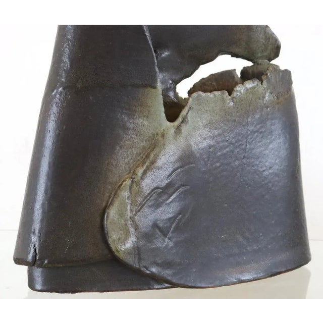 This hefty ceramic sculpture, dressed in dark colors, evokes the atmosphere of a mountain landscape in the nocturnal...