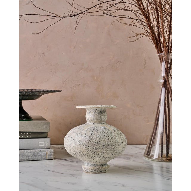 The Handcrafted "Calpide Granito" Decorative Vase by Canoa Lab is a sculptural stoneware vessel inspired by the historic...