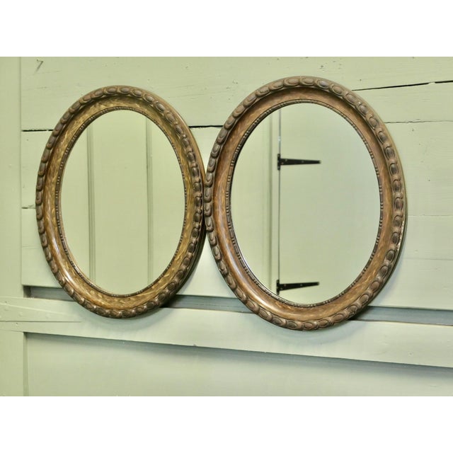 A pair of Simulated Wood Finish Oval Mirrors These Mirrors have very attractive wide moulded oval frames, these have a...