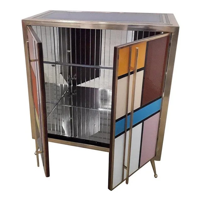 Two-doors sideboard with glass shelf, mirrored interior, entirely handmade, with wooden structure covered in colored...