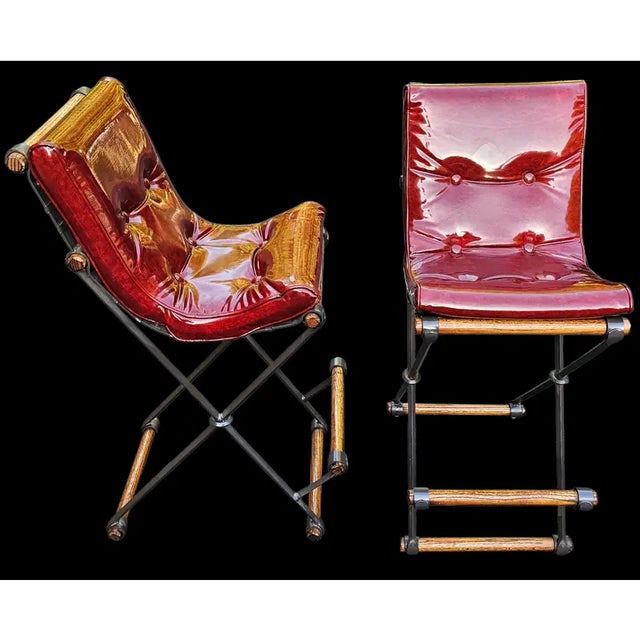 This Pair of Campaign "X" Wrought Iron and Oak Bar Stools Attributed to Cleo Baldon for Terra of California blends rugged...