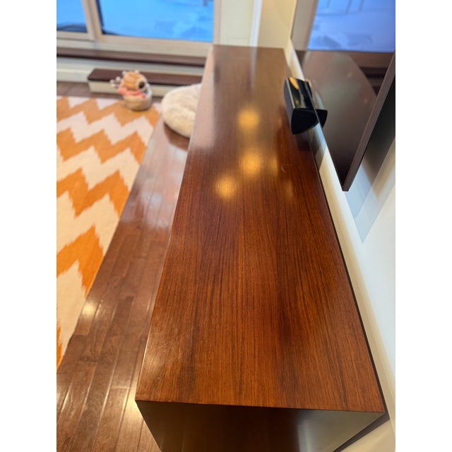 Credenza with a rich wood grain finish and highly functional storage. This unsigned piece was acquired by its current...