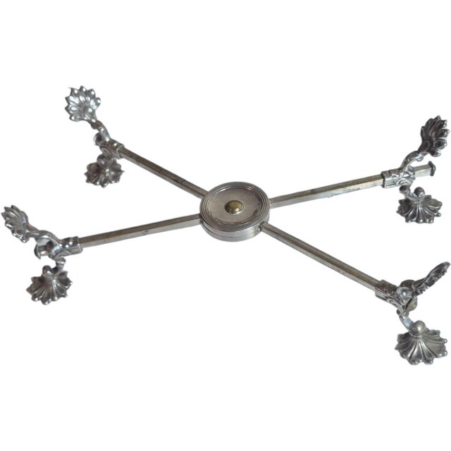 A vintage silver plated dish cross or trivet. It measures 13 inches when closrd. It can hold a 12" bowl.