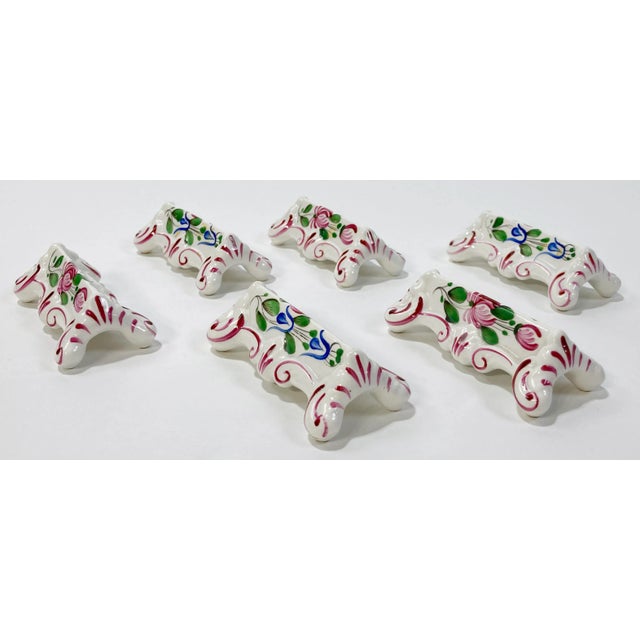 Set of six antique French hand made and hand-painted porcelain knife rests. Each depicts lovely floral design with deep...