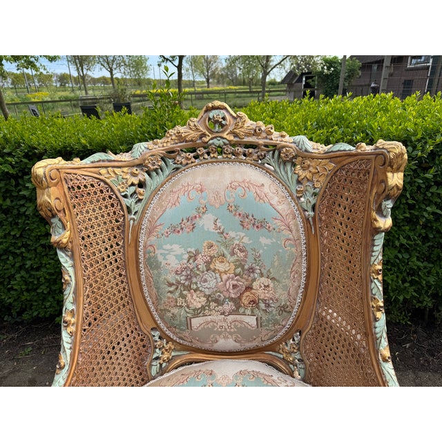 A charming pair of circa 1940 French Louis XVI-style bergère chairs, crafted from carved beechwood with cane side panels,...