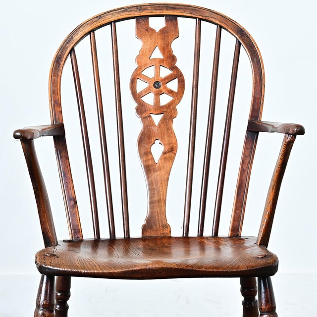 A handsome mid-19th century English wheelback Windsor chair built from solid elm, ash, and beech. Hand-crafted in the...