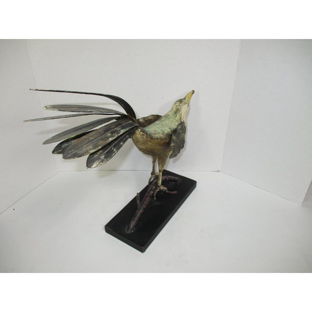 A handmade bird figure, made of toile in the primitive style. The bird is perched on a branch, it has leaf like wings and...
