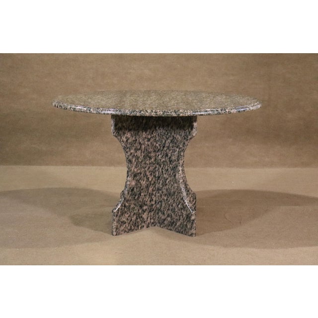 Simply designed polished marble dining table set on an X frame stone base.