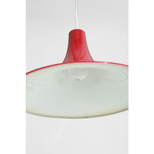 Ready to hang Scandinavian pendant featuring a glossy red spun metal shade with clean, flared profile. A timeless accent...