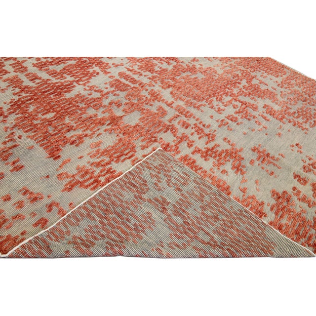 Beautiful modern Apadana's Safi Collection hand-knotted wool rug with the beige and gray field. This Modern rug has orange...
