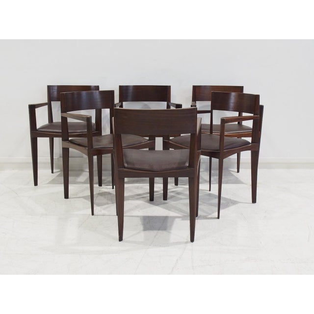 Set of six Italian modern dining chairs. Sleek design with elegantly shaped narrow legs. Solid dark stained wood and...