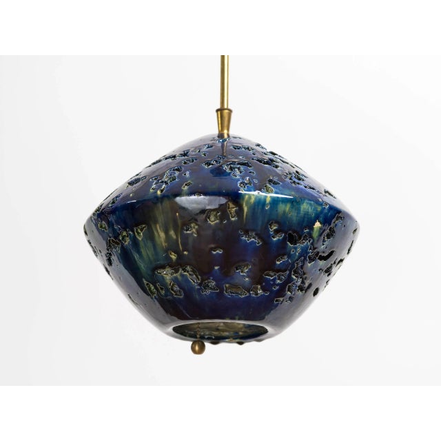 Italian 1960s Brutalist cut-out and glazed indigo ceramic sphere chandelier, with pull chain. Original brass rod and...