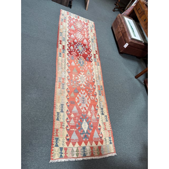 Design Plus Gallery presents a 3ft × 10ft 3in Handwoven Flatweave Kilim Runner. This kilim runner displays geometric...