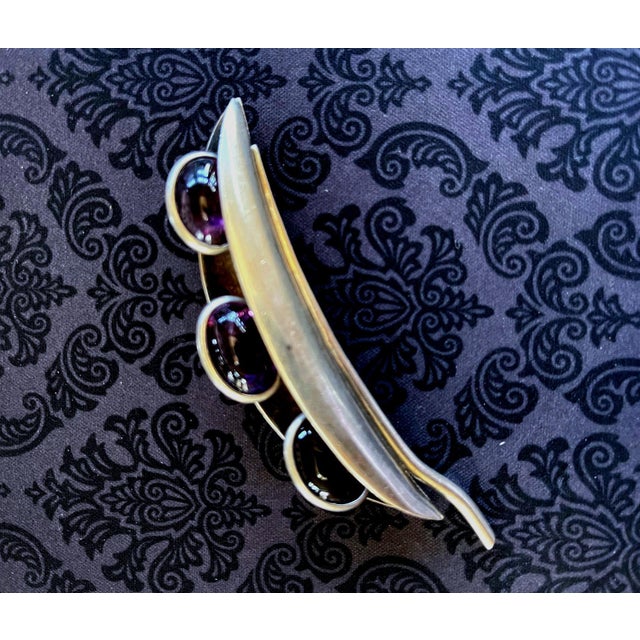 A Mid-Century Modern sterling silver brooch with three amethyst gem stones by Mexican Taxco silversmith Antonio Pineda...