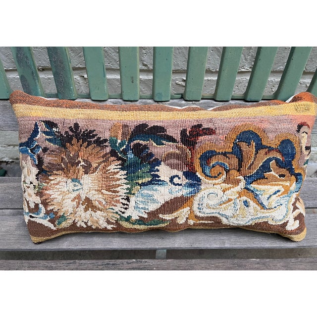 A charming decorative pillow crafted from an exquisite 18th-century tapestry featuring a striking pattern of large,...
