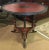 Unique tripod base table with lower shelf features painted wood frame with tooled leather accents painted with antique red...