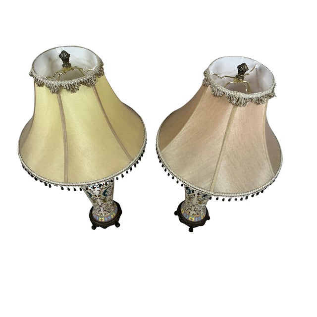 Pair of vintage matching Bombay table lamps with a painted floral pattern. The Lamps come with a matching beaded fringe...