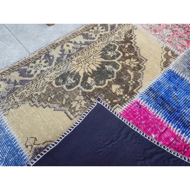 This is a vintage Turkish Oushak rug from the Mid 20th Century. The piece was hand-knotted.