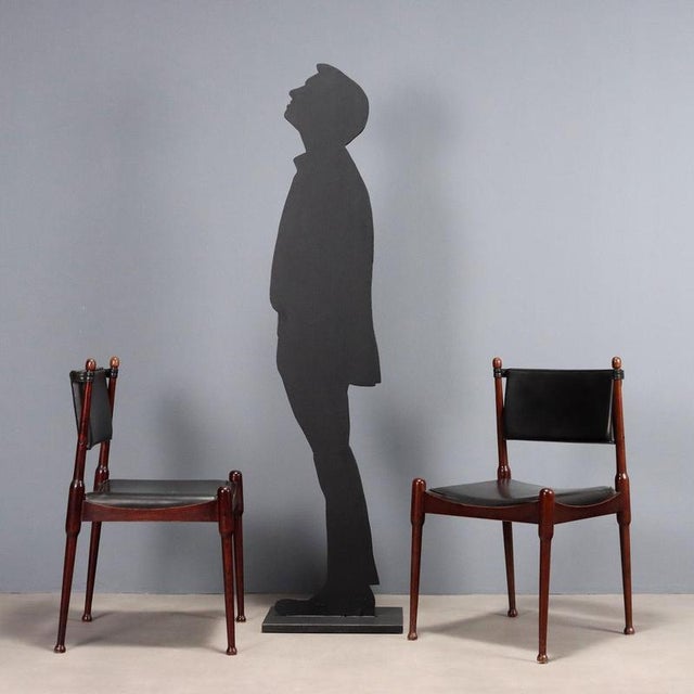 Pair of wood chairs, seat and back in foam with imitation leather upholstery. This piece is attributed to the mentioned...