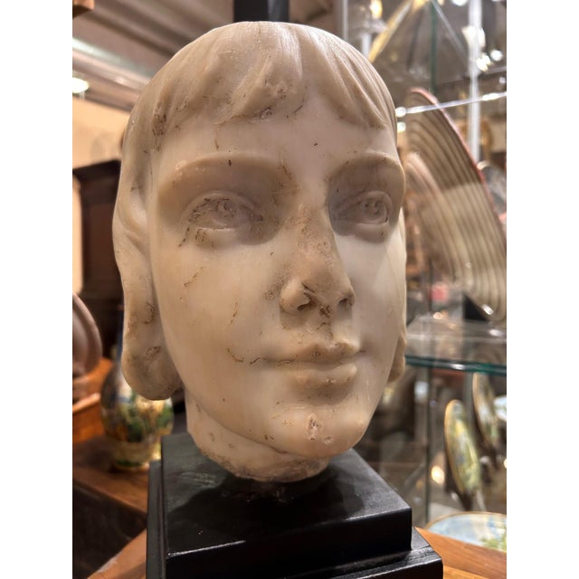 Interesting head in white Carrara marble with monumental proportions depicting a child, probably a young scion of high...