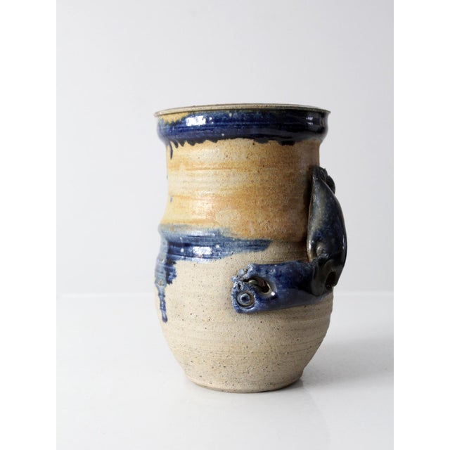 This is a vintage studio pottery vase. The handmade vase has a bold abstract style has tan glaze with blue drip detailing...