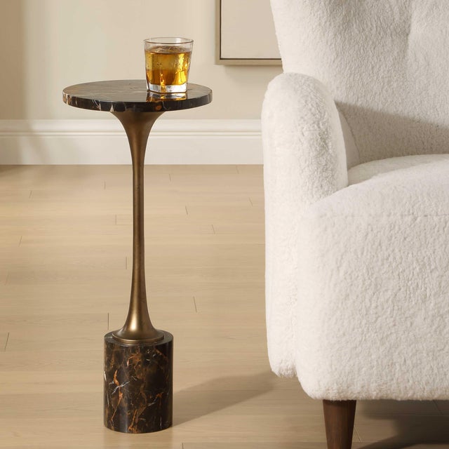The Karnes Drink Table Is Defined By A Tapered Bronze Stem, Which Supports A Striking Black Marble Tabletop And A Matching...