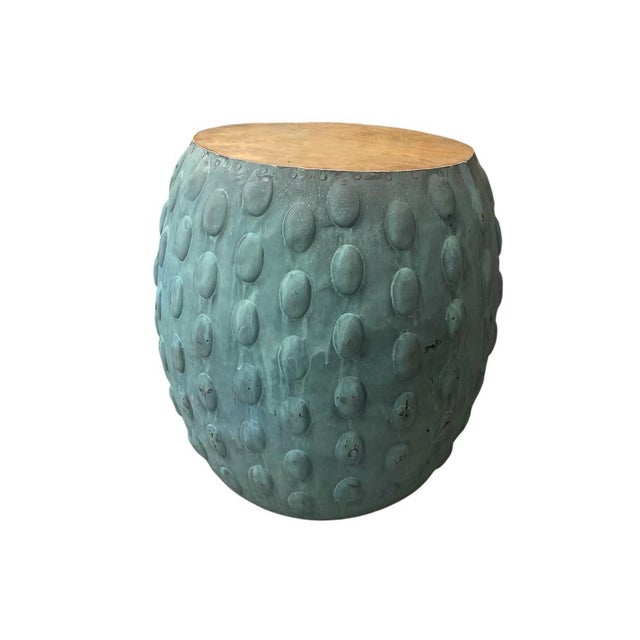 This drum-form side table offers a compelling blend of organic texture and industrial materiality. The base is crafted...