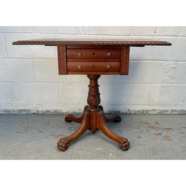 This distinguished American sewing table features a classic drop-leaf design, offering versatile surface space when...