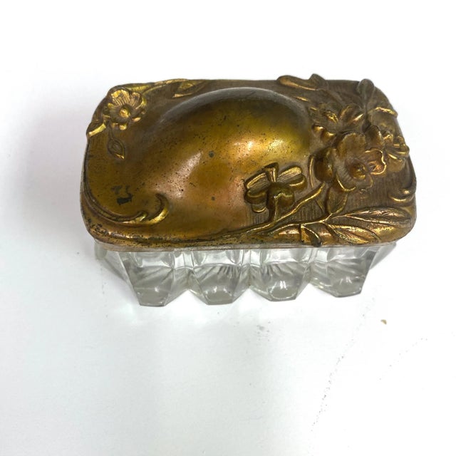 This piece is from the early 20th century. The bottom is beautiful cut glass and the lid is a brass toned metal with a...