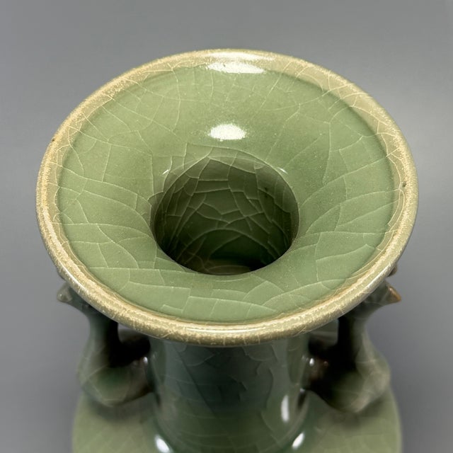 This antique Chinese Longquan celadon vase features a pair of phoenix-shaped handles on both sides. The glaze presents...