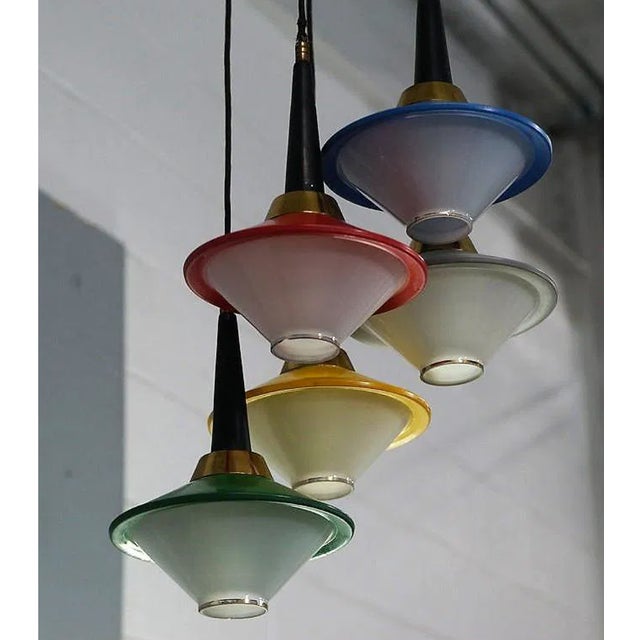 A stunning vintage Italian mid-century chandelier, featuring five uniquely colored glass diffusers—red, green, blue, grey,...