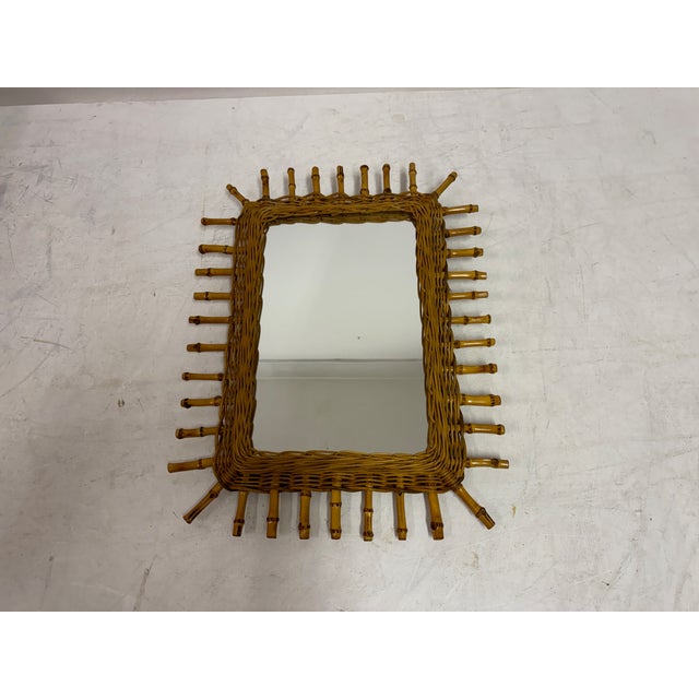 A mid-century bamboo wall mirror with a bold, sculptural frame and strong decorative presence. The rectangular mirror...