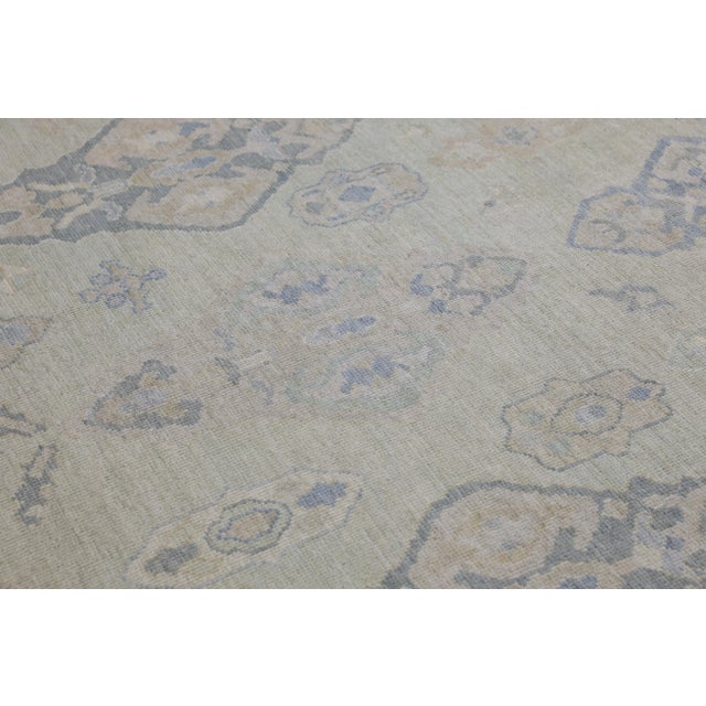 This modern Turkish Oushak rug is a stunning piece of art that has been handwoven using traditional techniques by skilled...