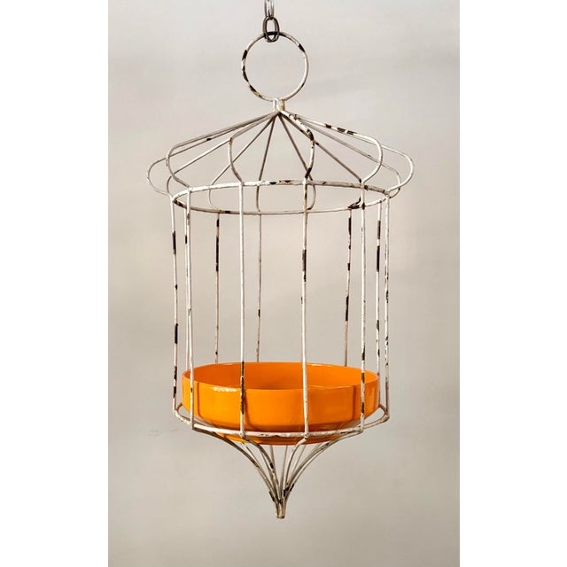 This charming mid-century modern, 1950s hanging plant stand features a sculptural white-painted metal wire frame with a...